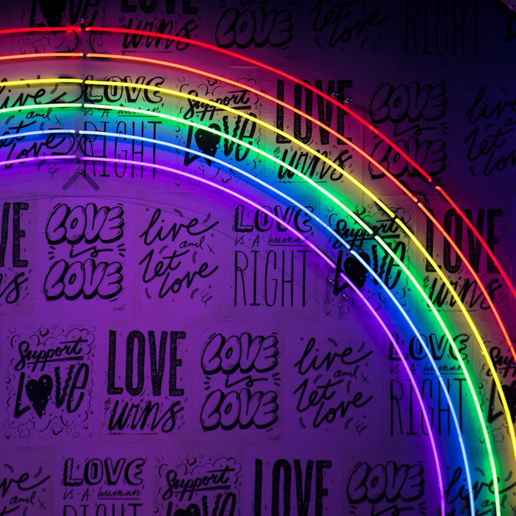 Rainbow Neon Sign with Love Words in Background
